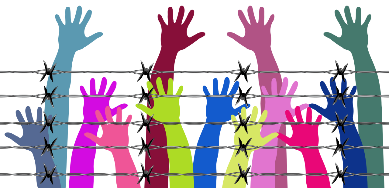 Human rights hands in the air behind barbed wire